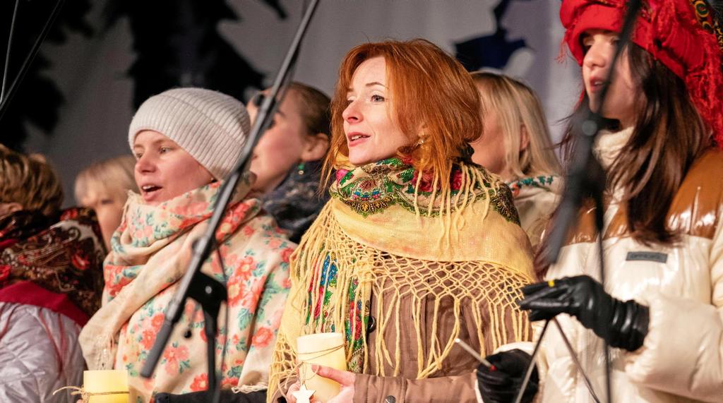 Foto: Chorsängerinnen in Jacken, Schals und einige mit Mützen